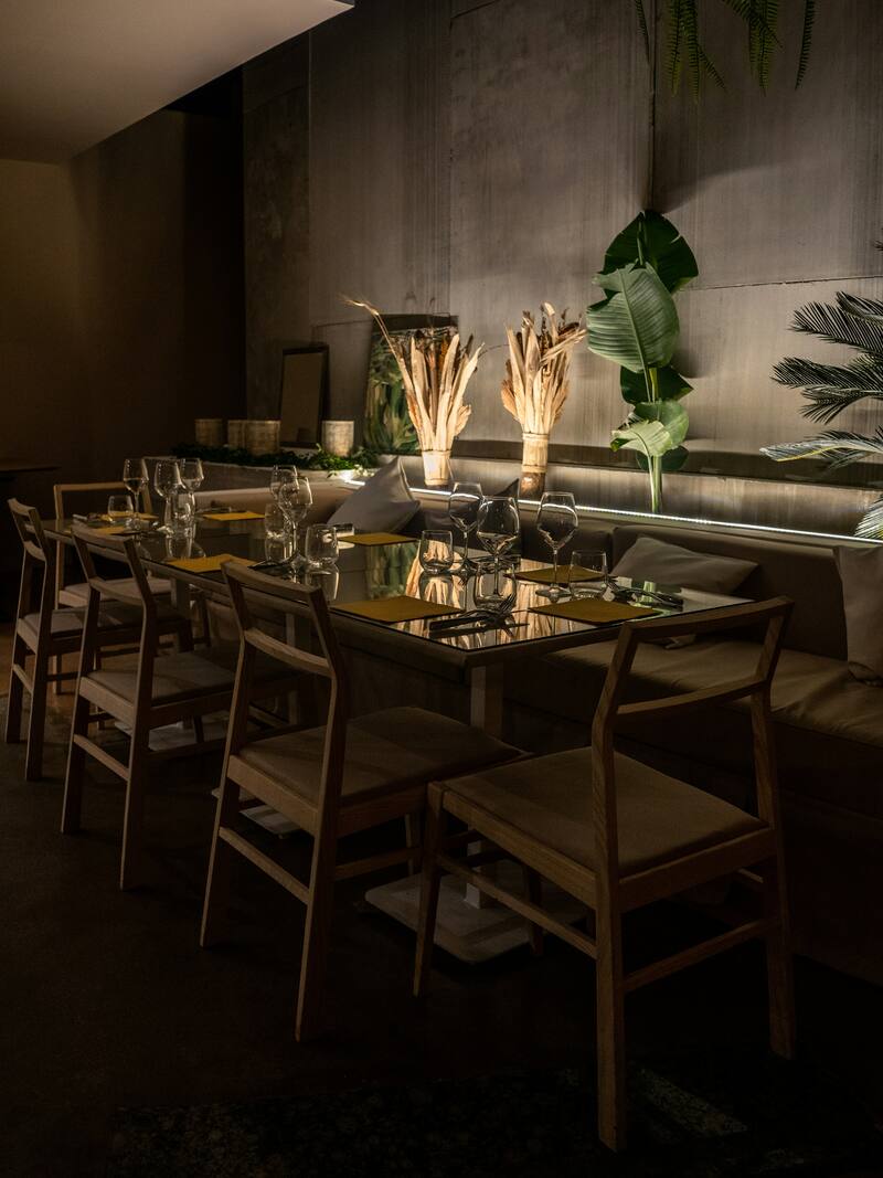 Salle à manger tamisée, tables dressées et chaises en bois
